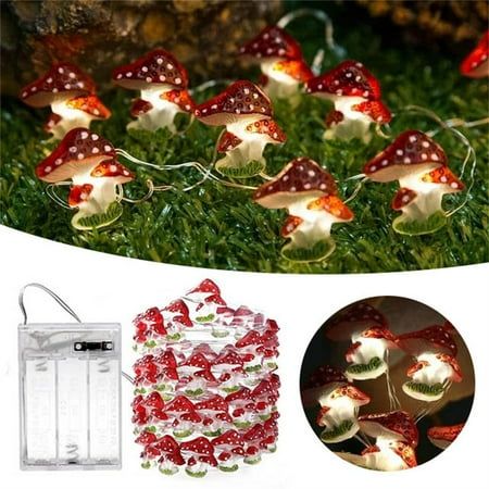 fairy lights with red and white mushrooms on them in the grass next to a bag