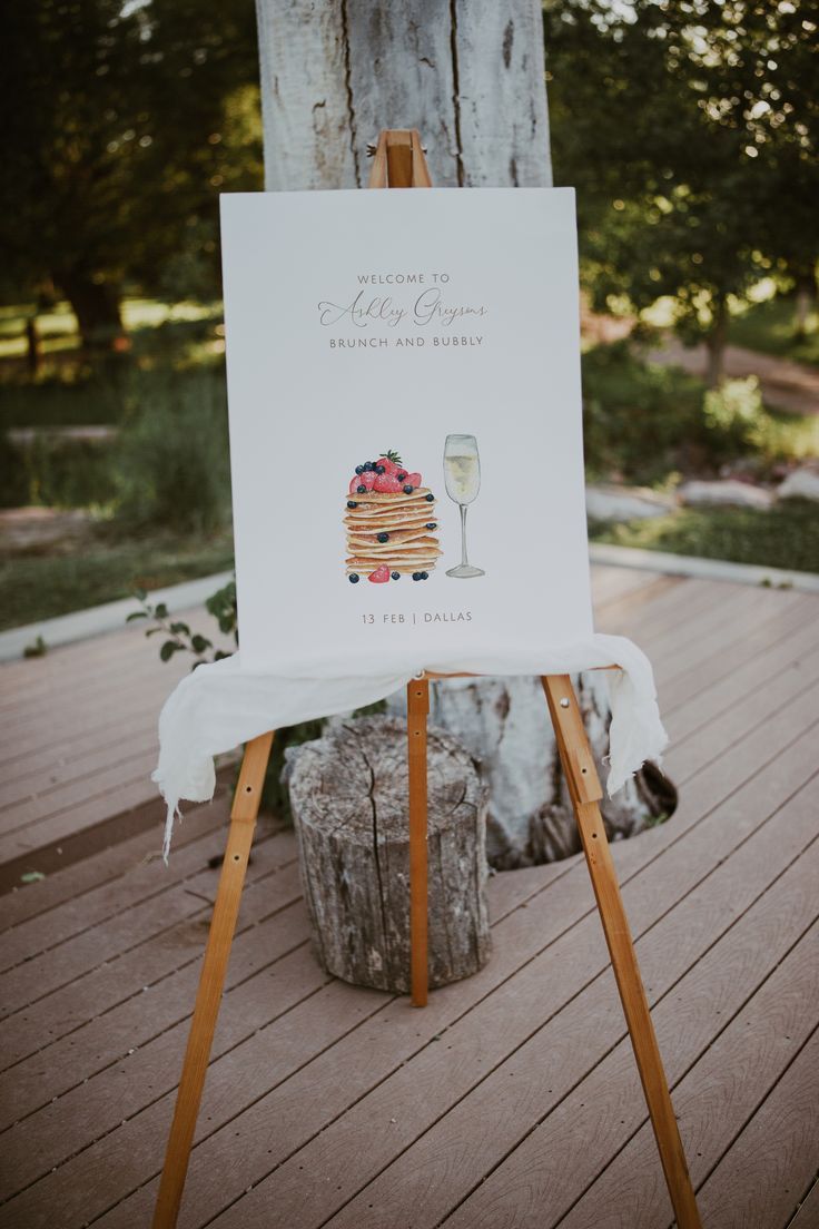 a sign that is sitting on top of a wooden easel next to a tree