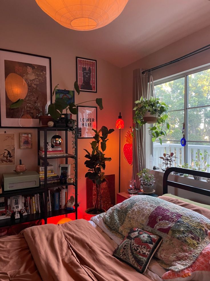 a bed room with a neatly made bed and lots of plants on the windowsill