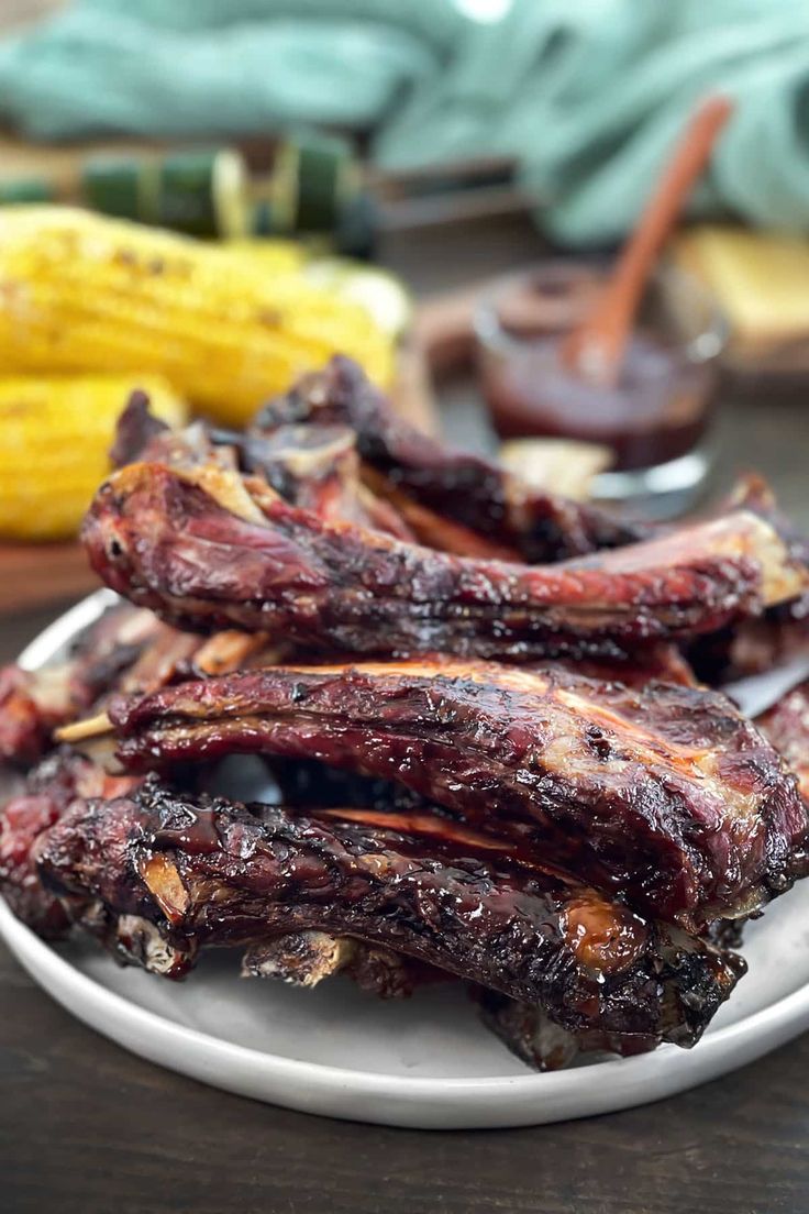 ribs on a plate next to corn and ketchup