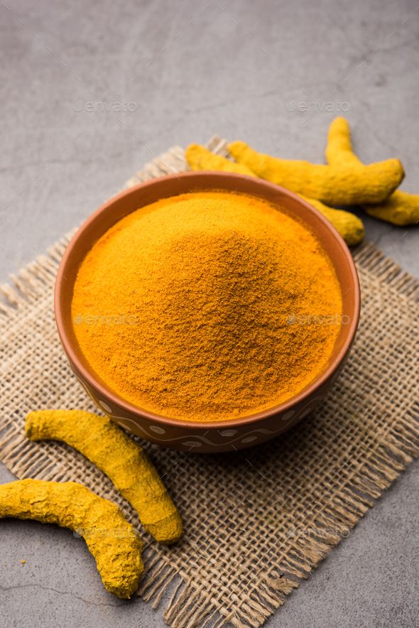 a bowl filled with yellow powder next to two banana peels on top of a cloth