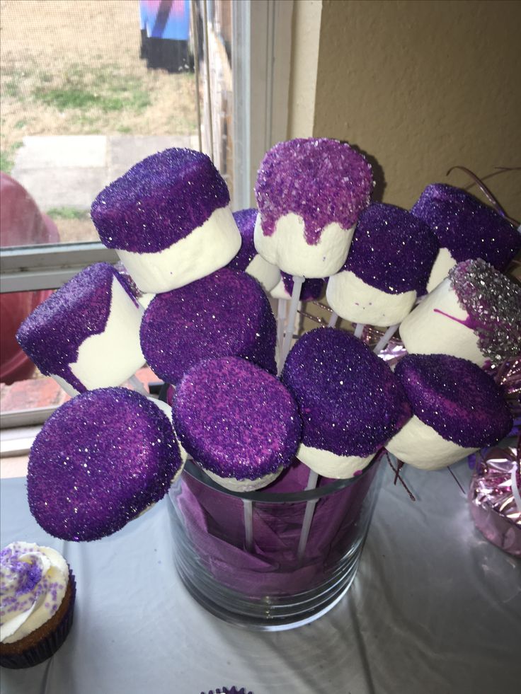 purple and white cupcakes in a vase on a table