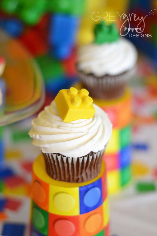 cupcakes with white frosting and lego decorations