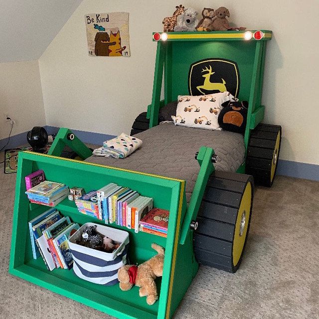 a child's bed made to look like a tractor with books and toys in it