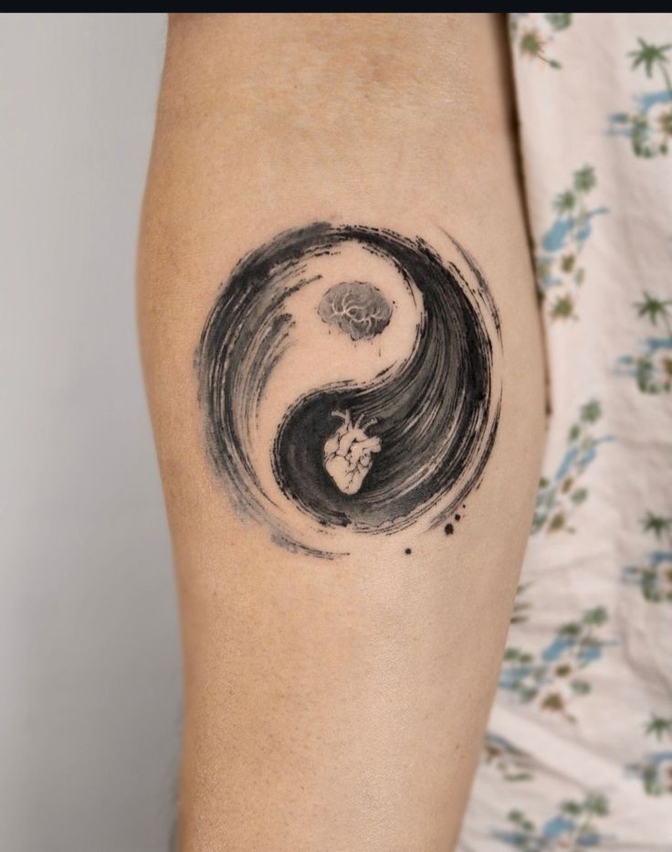 a woman's arm with a tattoo on it that looks like a yin - yang symbol