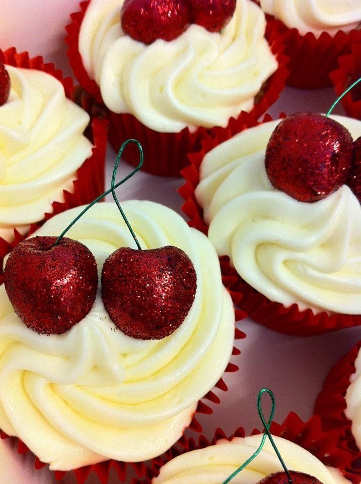 cupcakes with white frosting and red decorations