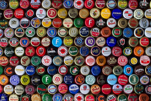 many different colored bottle caps are stacked together