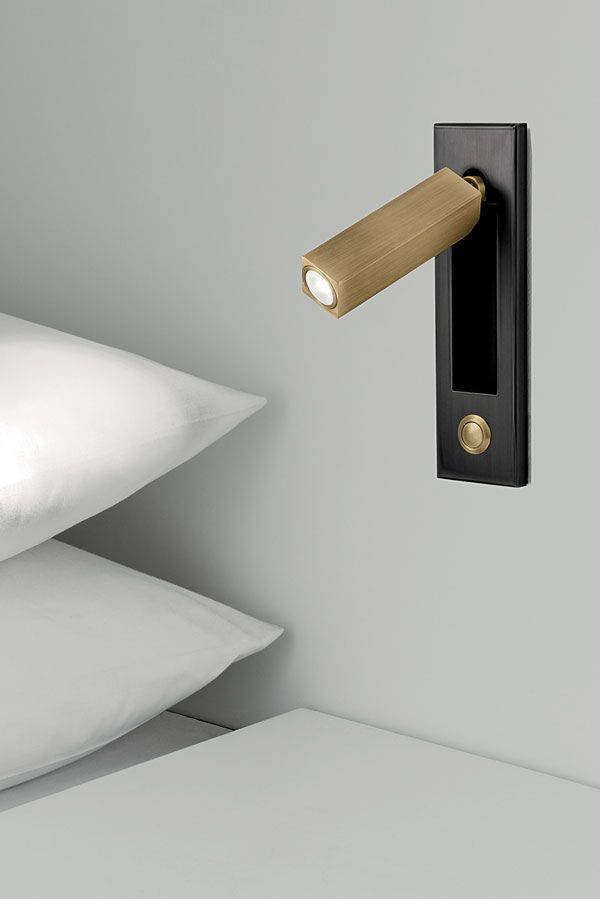 a light that is on the side of a wall next to some pillows and pillow cases