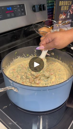 a person stirring food in a pot on the stove