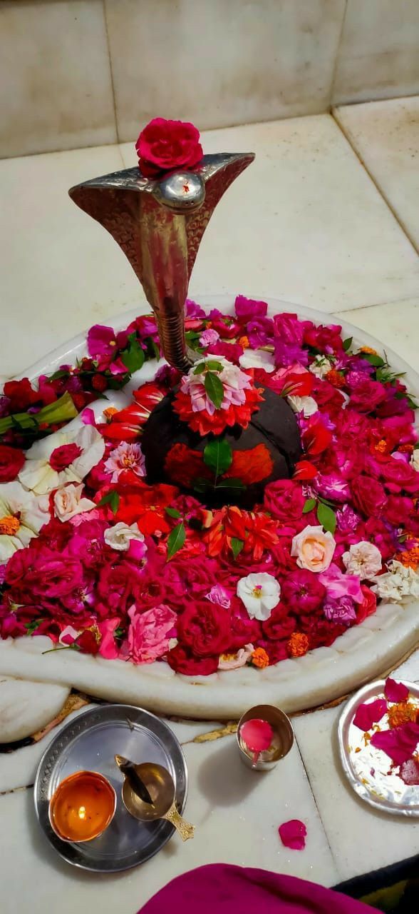 there is a flower arrangement on the table with plates and bowls around it, including flowers