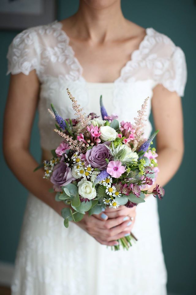 a woman holding a bouquet of flowers in her hands