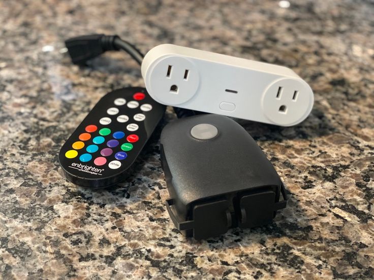 two remote controls sitting next to each other on top of a granite countertop,