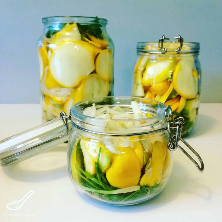 three jars filled with pickles and lemons