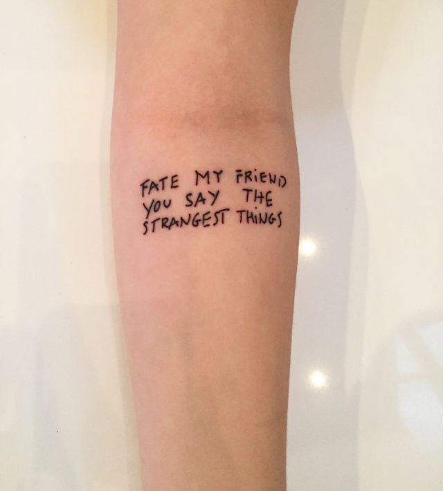 a person with a tattoo on their arm that says, fate my friend you say the strangest things