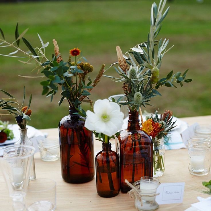 there are many vases with flowers in them on the table