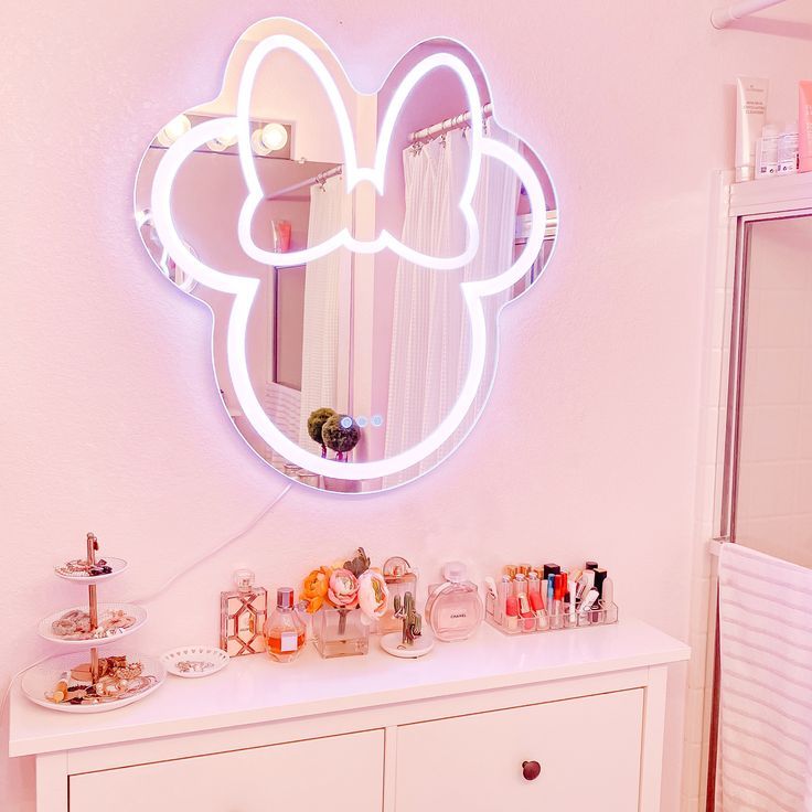 a mirror that is on top of a dresser next to a shelf with makeup and other items