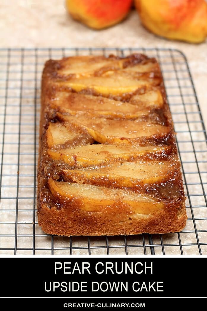 pear upside down crunch coffee cake on a cooling rack with peaches in the background