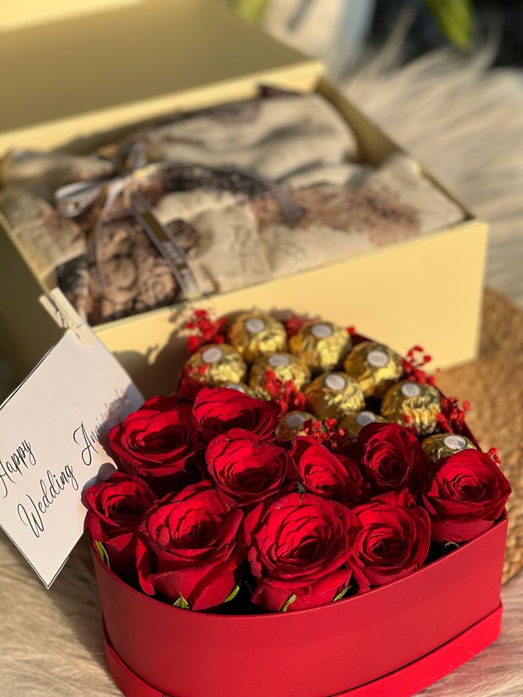 a heart shaped box filled with chocolates and red roses next to a card that says happy valentine's day