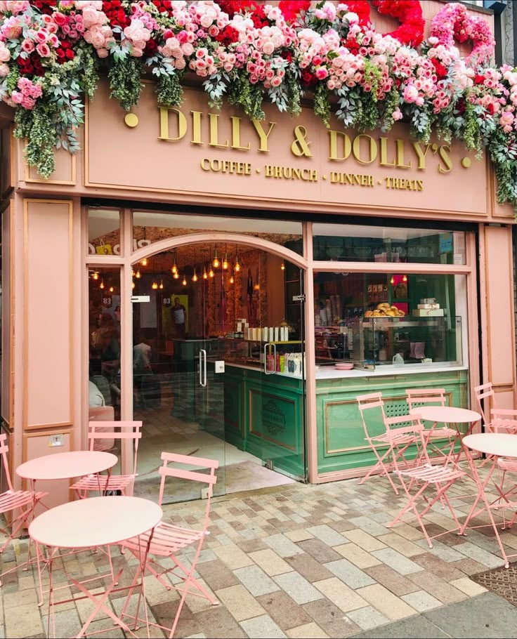 an outside view of a restaurant with pink chairs and tables in front of the window