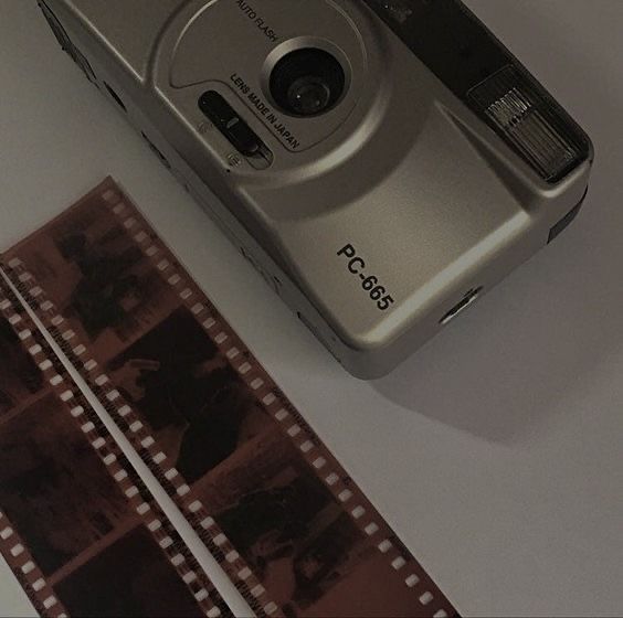 a camera sitting on top of a table next to a roll of film