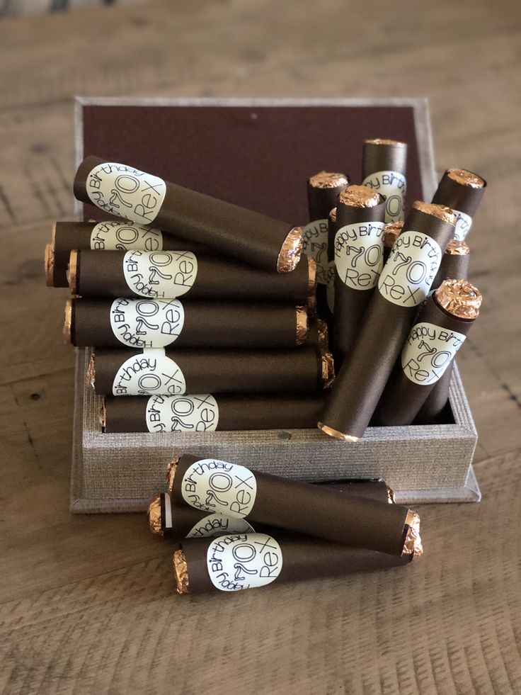 a box filled with lots of brown and white wrapped chocolates on top of a wooden table