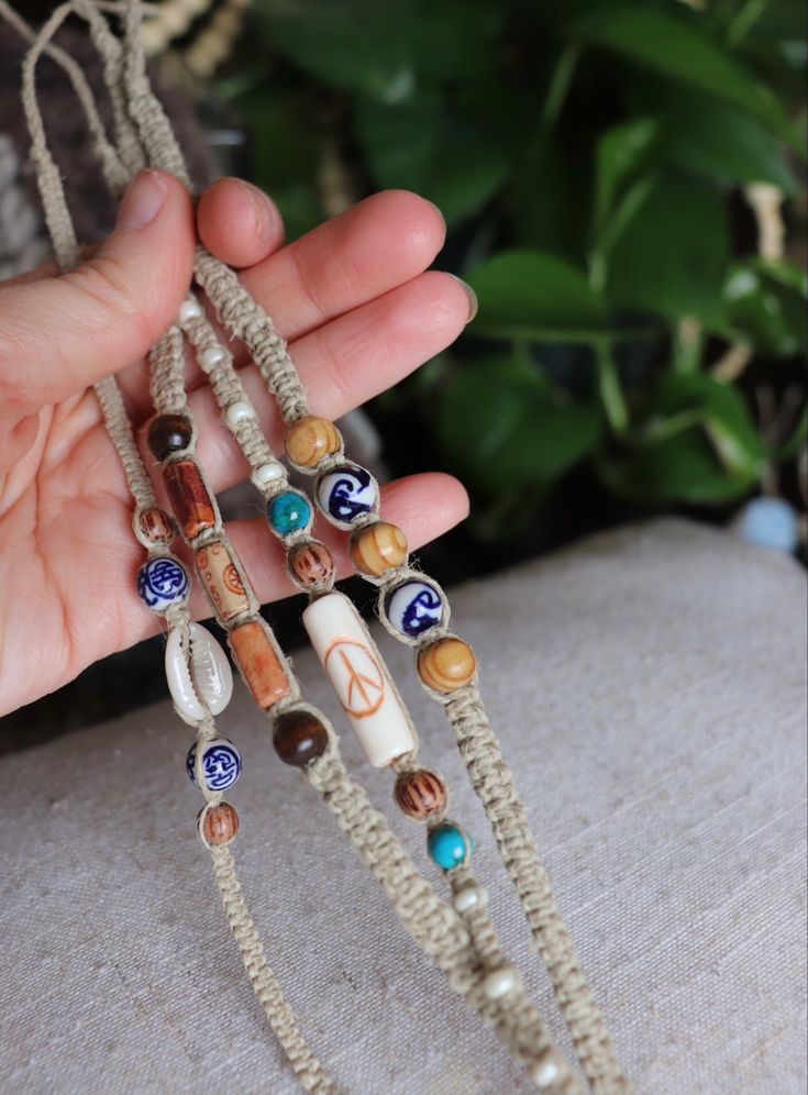 a person holding some kind of beaded necklace in their hand with other beads around it