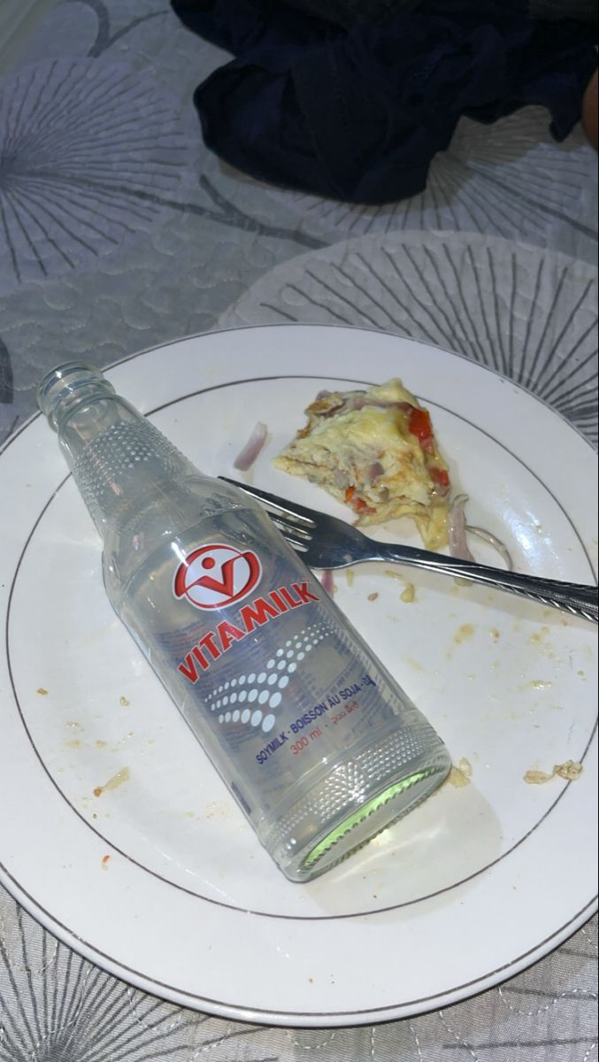 a bottle of vodka sitting on top of a plate next to a knife and fork