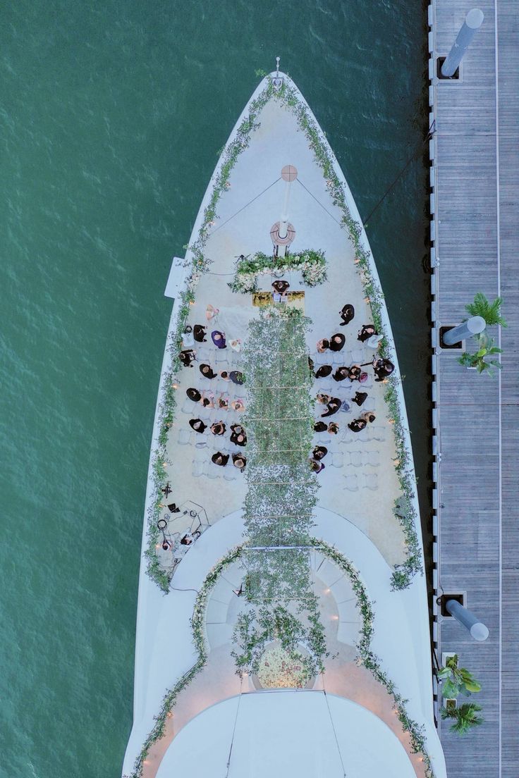 an aerial view of a wedding ceremony on the back of a boat in the water