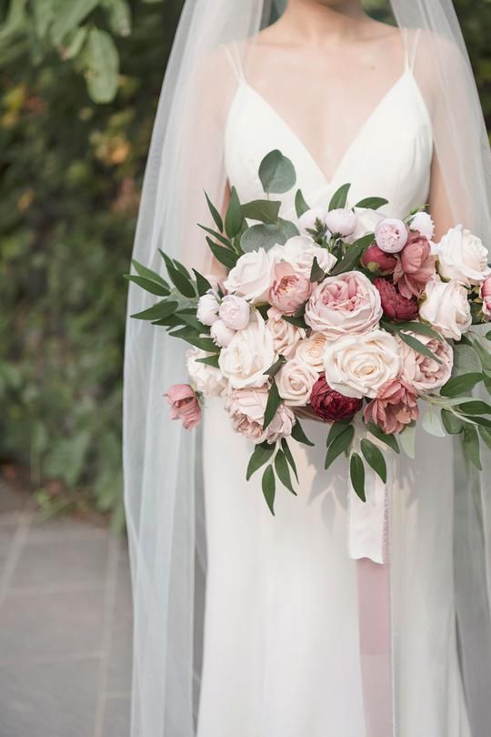 a bridal holding a bouquet of pink and white flowers