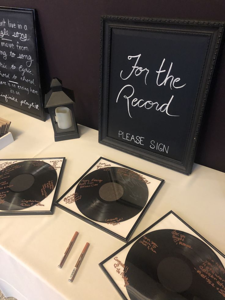 there are four records on the table with writing on them and two framed pictures next to each other