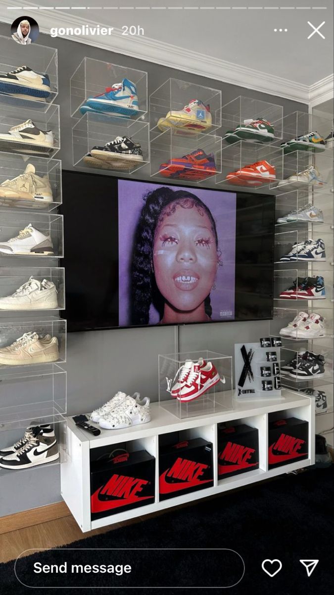 there is a display case with shoes on it and a television in the wall above