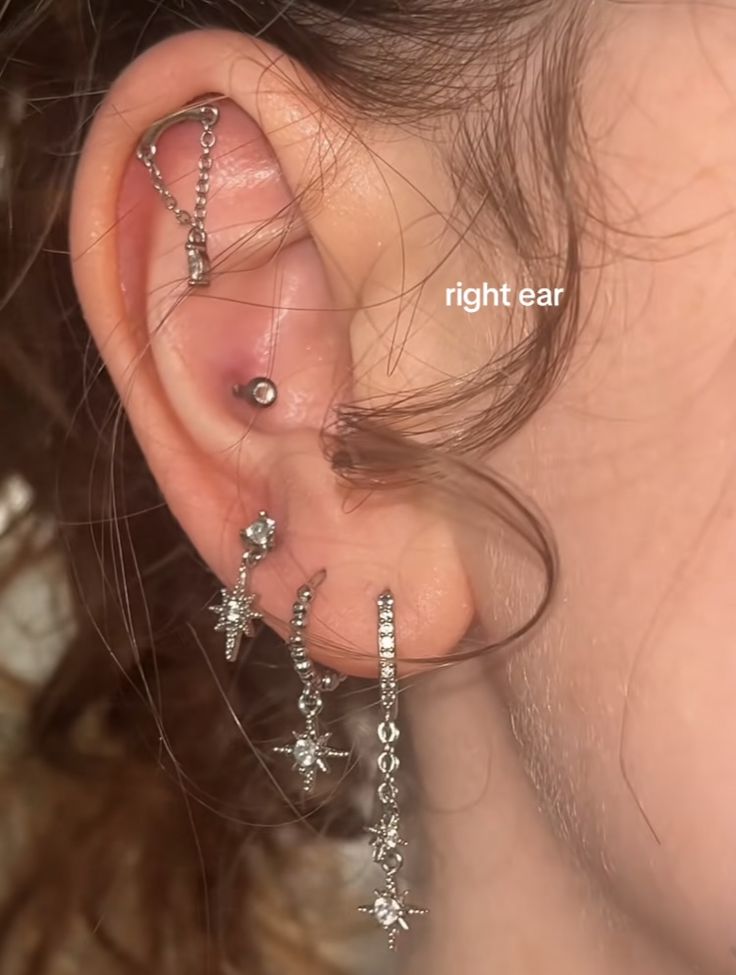 a woman with three ear piercings on her left ear and one behind the ear