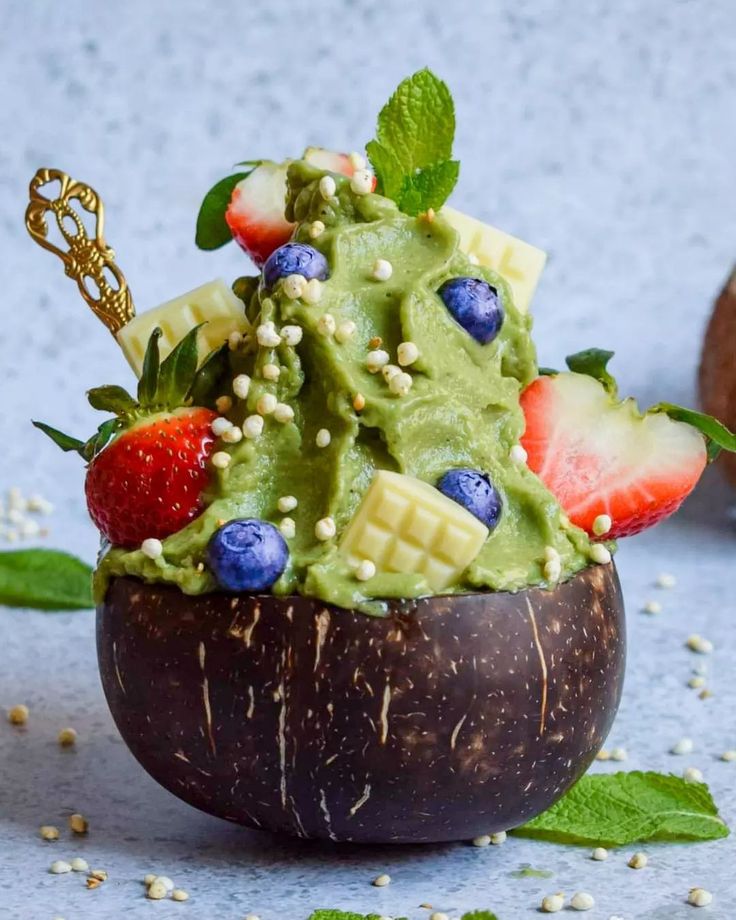 a fruit salad in a coconut shell with strawberries and blueberries