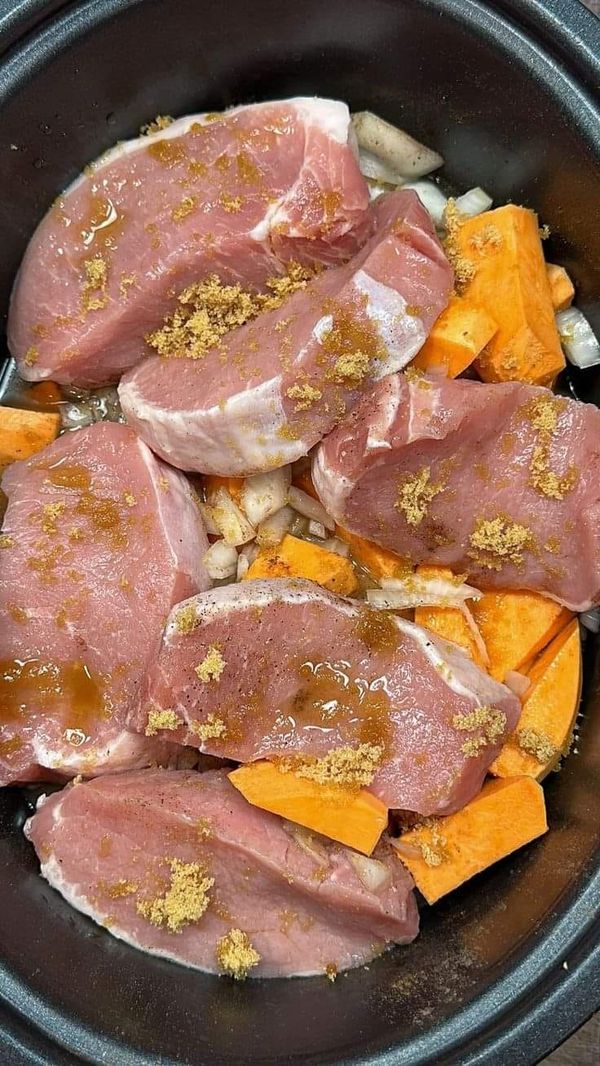 meat and vegetables in a slow cooker ready to be cooked