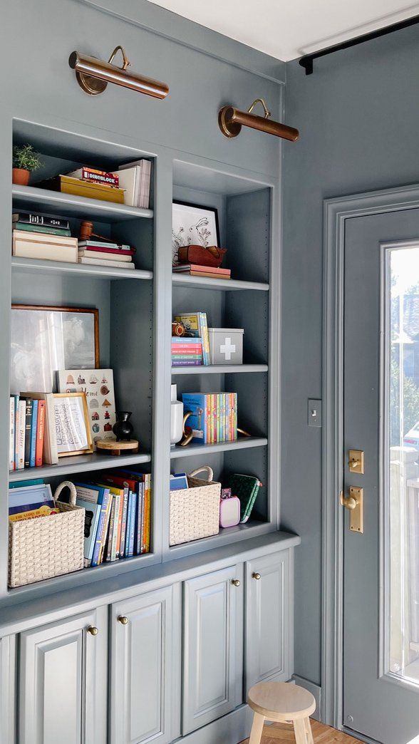 a book shelf with books and other items on it in a room that is painted blue