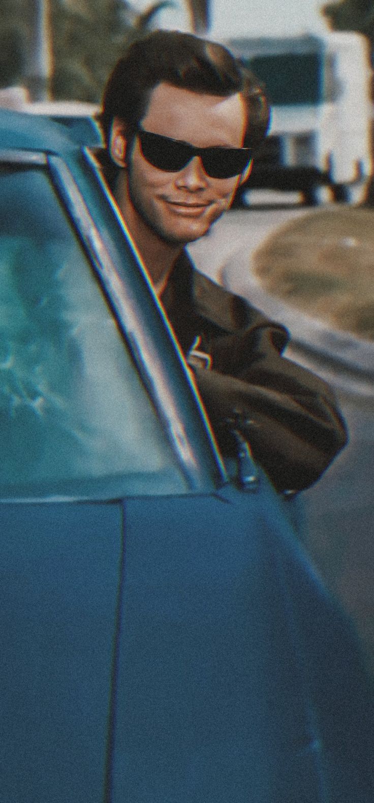 a man wearing sunglasses sitting in the driver's seat of a blue sports car