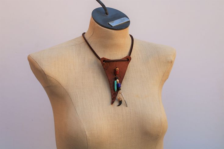 . . . these sell out often, and are re-stocked as soon as possible; but the designs are unique to each individual item: so if you like this one specifically, buy it now! . .  another Moyamensing Handmade original design to keep you heathens stylish Primitive Leather Talisman Tribal Necklace distressed,  6 oz   leather pendant approximately 3 1/2" x  2 1/2", stitched claw, beads, shell ornaments  approximately 25" leather lace with stitched loop for adjustable closure simple, primitive, original, Unique Leather Jewelry For Festivals, Viking Style Handmade Festival Jewelry, Artisan Hand-stitched Festival Jewelry, Handmade Leather Necklaces For Festivals, Handmade Leather Festival Necklaces, Handmade Leather Necklace For Festivals, Handmade Bohemian Leather Necklace, Bohemian Leather Necklace For Festivals, Long Brass Amulet Necklace