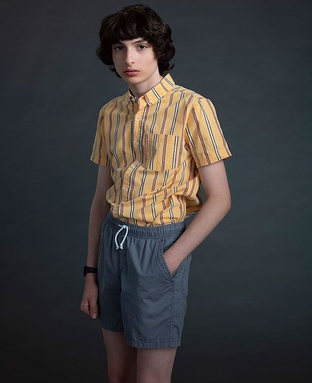 a young man wearing shorts and a yellow shirt