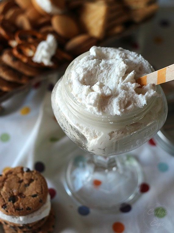 an ice cream sundae in a glass next to cookies and crackers on a table