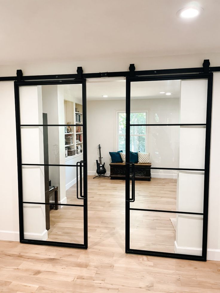 an empty room with sliding glass doors on the wall and hardwood flooring in front of it