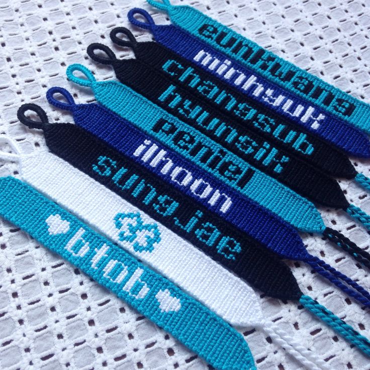 four blue and white lanyards with name tags attached to them on a table