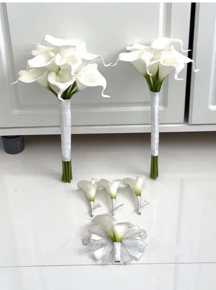 three white flowers sitting on top of a counter