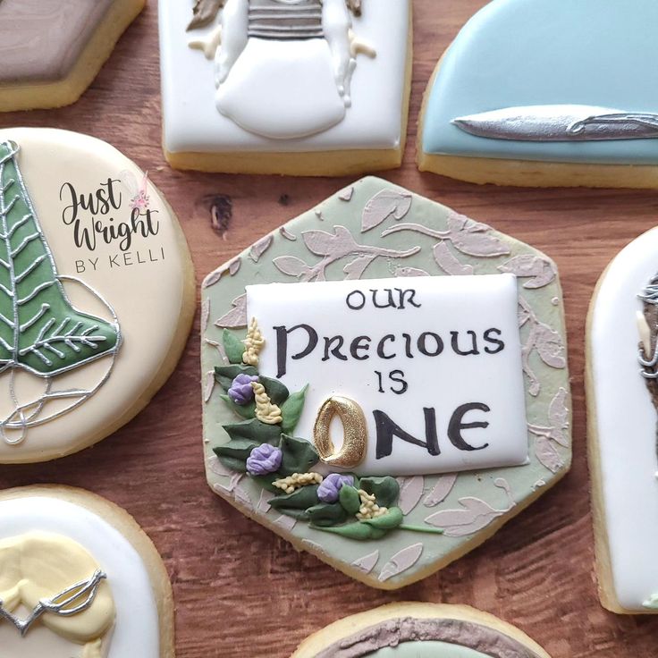 decorated cookies are arranged on a table with the words our precious is one written in frosting