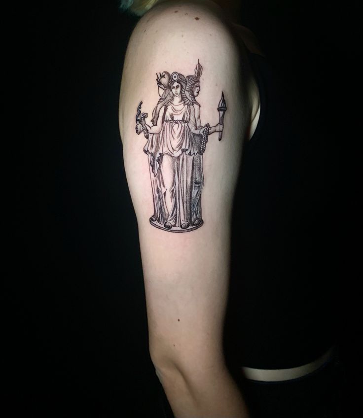 a woman's arm with a statue tattoo on it