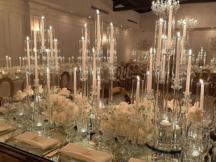 a table is set with candles, flowers and napkins for an elegant wedding reception