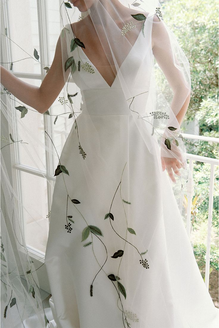 a woman in a white dress with flowers on it