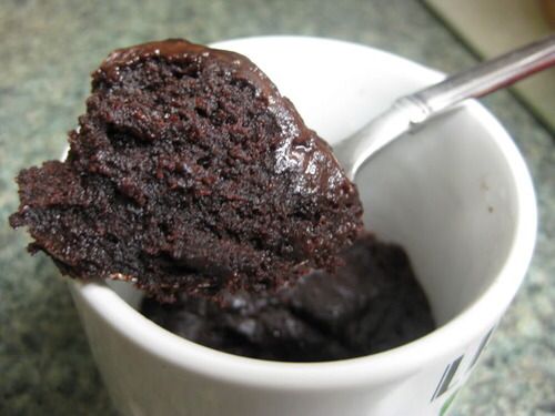 a spoon in a cup filled with chocolate cake