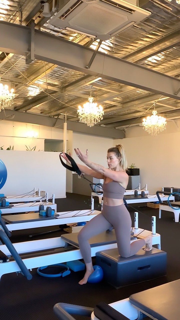 a woman is doing exercises on an exercise machine