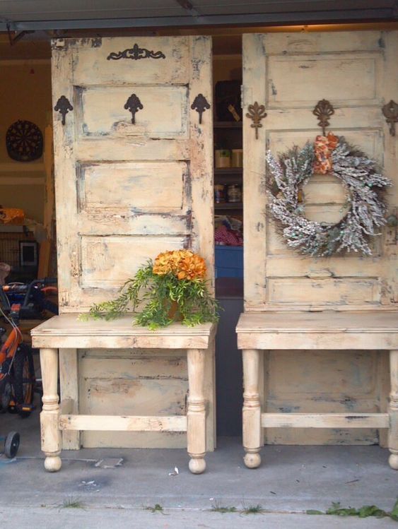 two old wooden doors with wreaths on the top and bottom, sitting next to each other