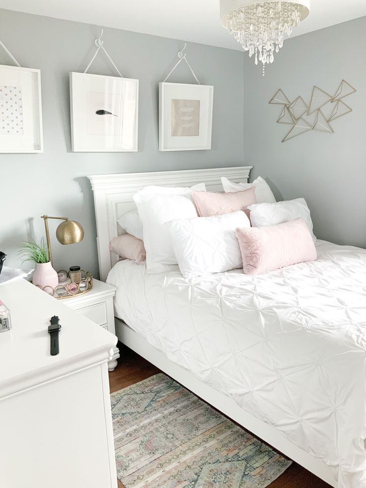 a white bed sitting in a bedroom on top of a wooden floor next to a dresser